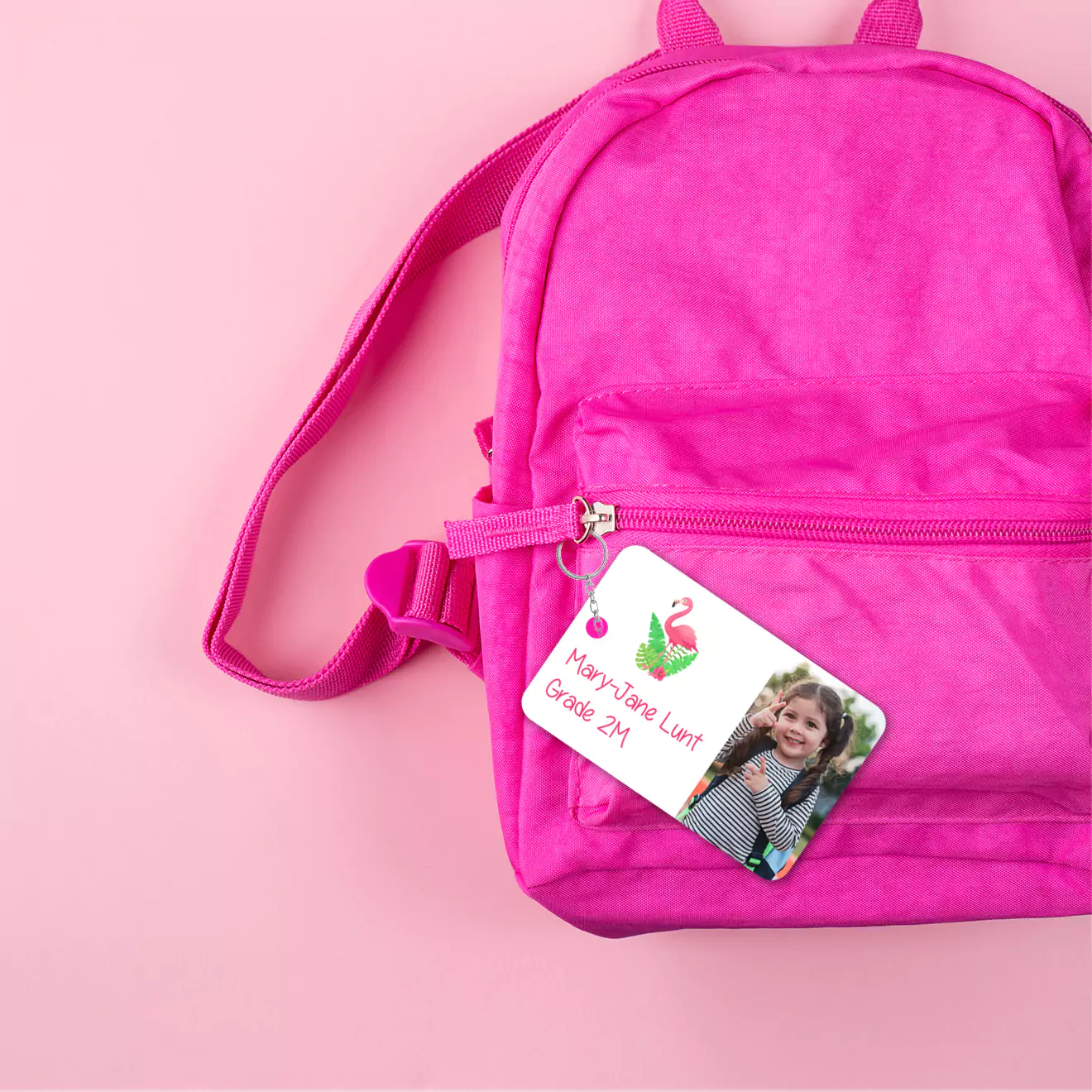 Bright pink school bag with a colourful bag tag attached, adding a personalised and stylish touch while making the bag easily identifiable and unique.