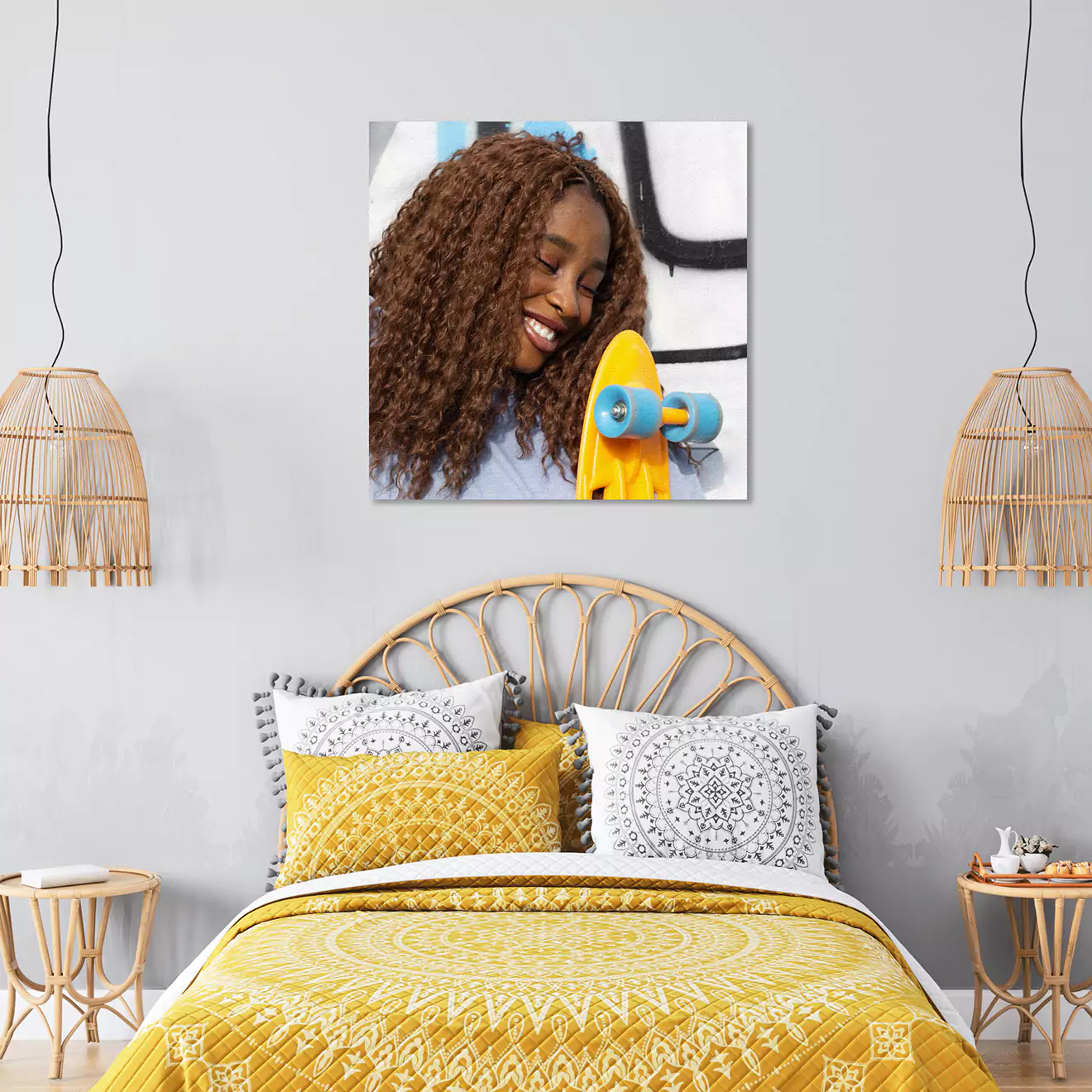 Bedroom with a rattan headboard and yellow bedding, featuring a wall-mounted photo canvas of a smiling person holding a skateboard. Two wicker pendant lights hang on either side of the bed.