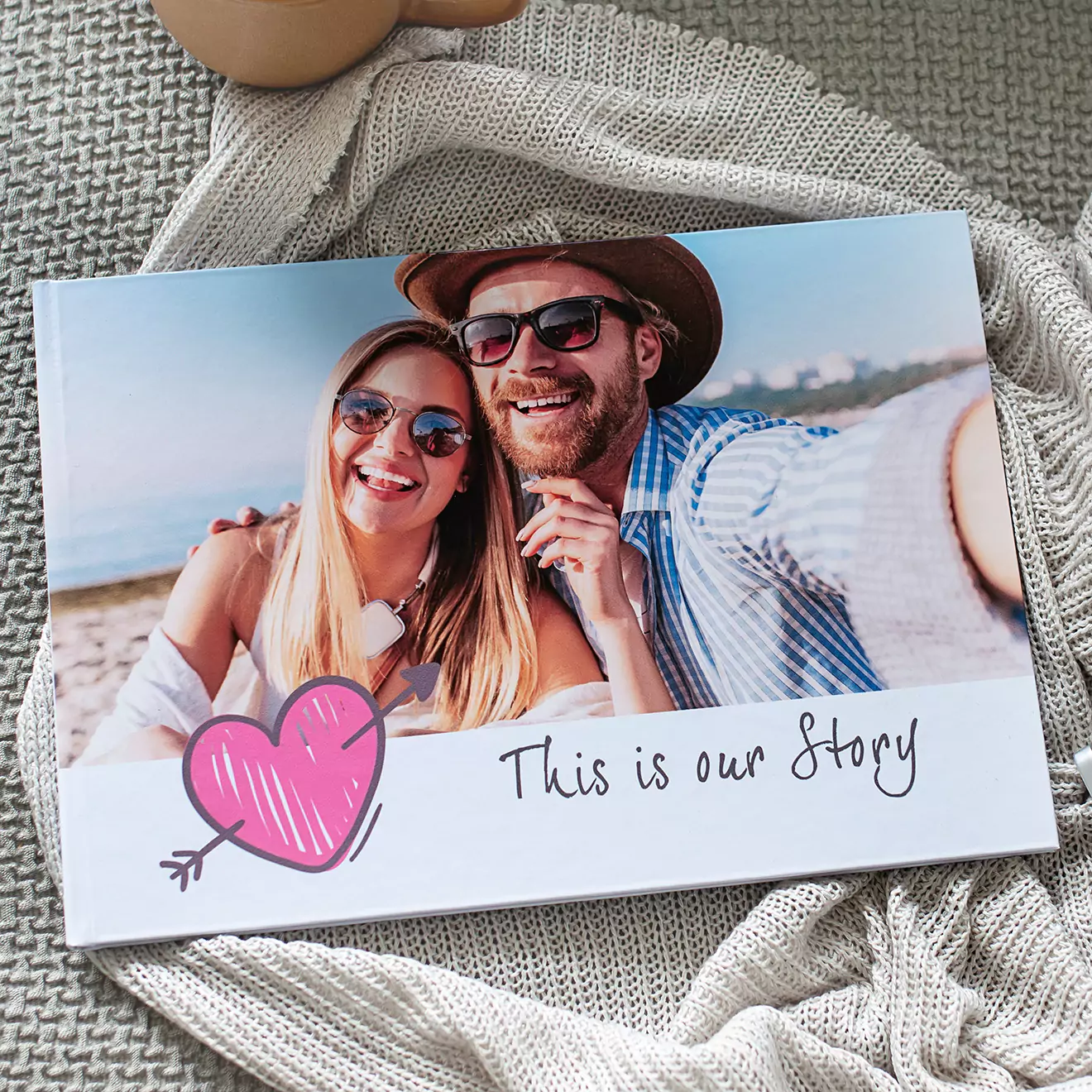 Hardcover photobook featuring a couple on the cover, with a decorative heart and the inscription 'This is our story'. Ideal for romantic gift or keepsake.