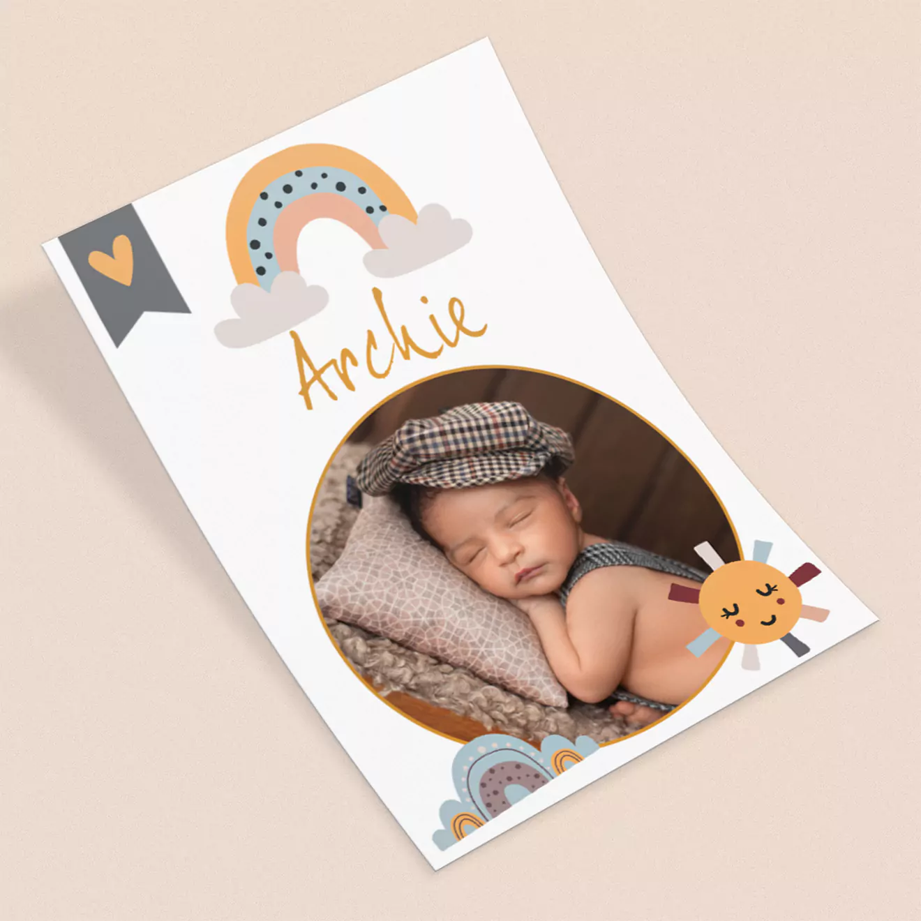 Personalised baby photo card featuring a sleeping infant named Archie, adorned with cute illustrations of a rainbow, heart, and sun, on a beige background.