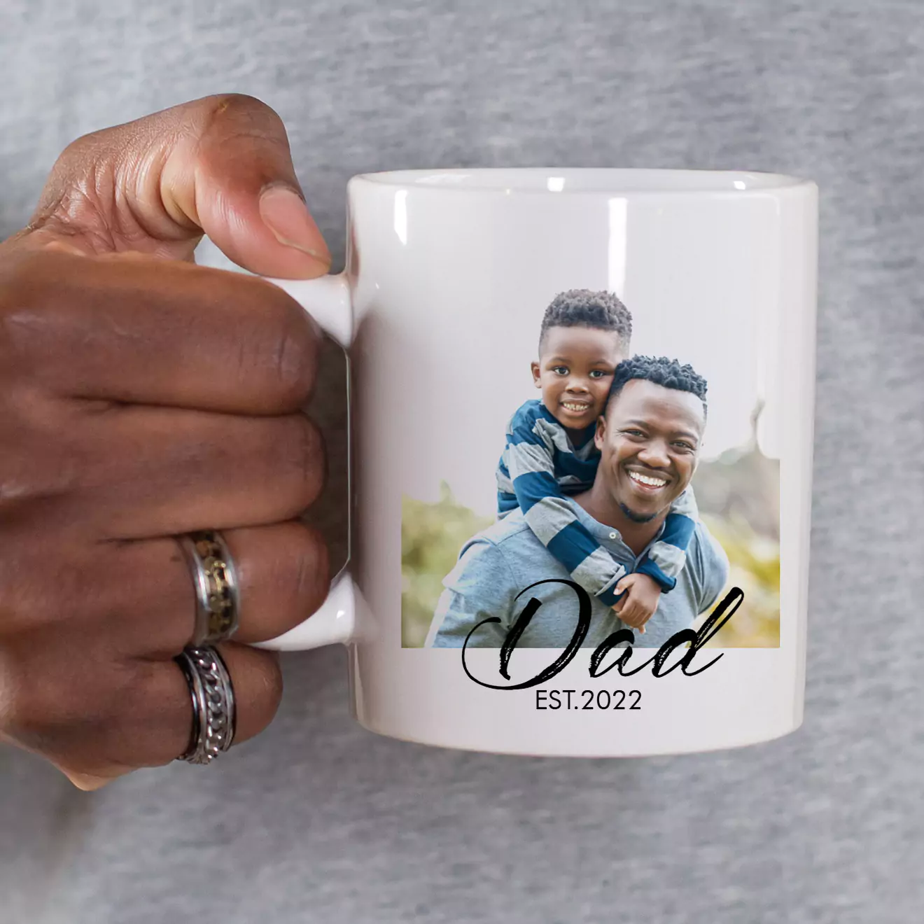 Close-up of hands holding a personalised mug with 'Mom Est.' theme, celebrating motherhood with a custom touch, perfect for gifting on Mother’s Day or any special occasion.