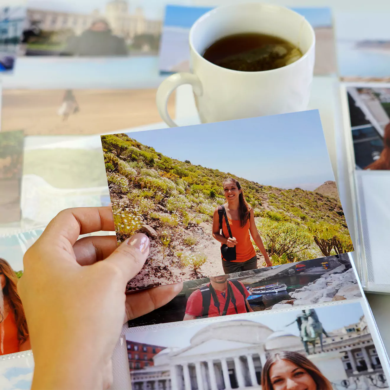 Assortment of freshly printed photo prints spread out on a desk, showcasing a variety of images and moments captured.