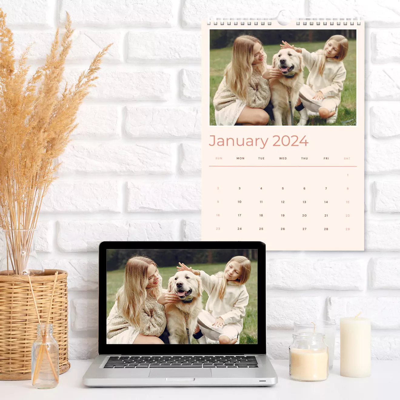 'n Persoonlike 2024 muurkalender met 'n gesinsfoto, vertoon bo 'n skootrekenaar met dieselfde prentjie. Ideaal vir geskenke vir haar, Kersgeskenke, of Valentynsdag geskenkidees. Fotoboek en skryfbehoeftes op 'n wit baksteenmuur agtergrond.