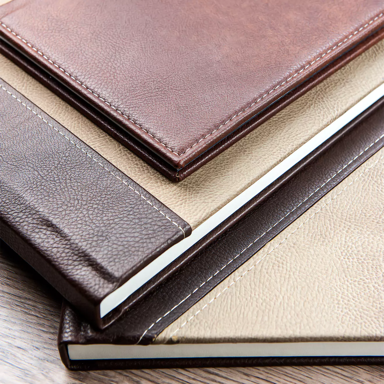 Collection of elegant leather-bound photo albums in various shades of brown and beige, showcasing high-quality stitching and durable covers. Ideal for Wedding albums, and special occasions.