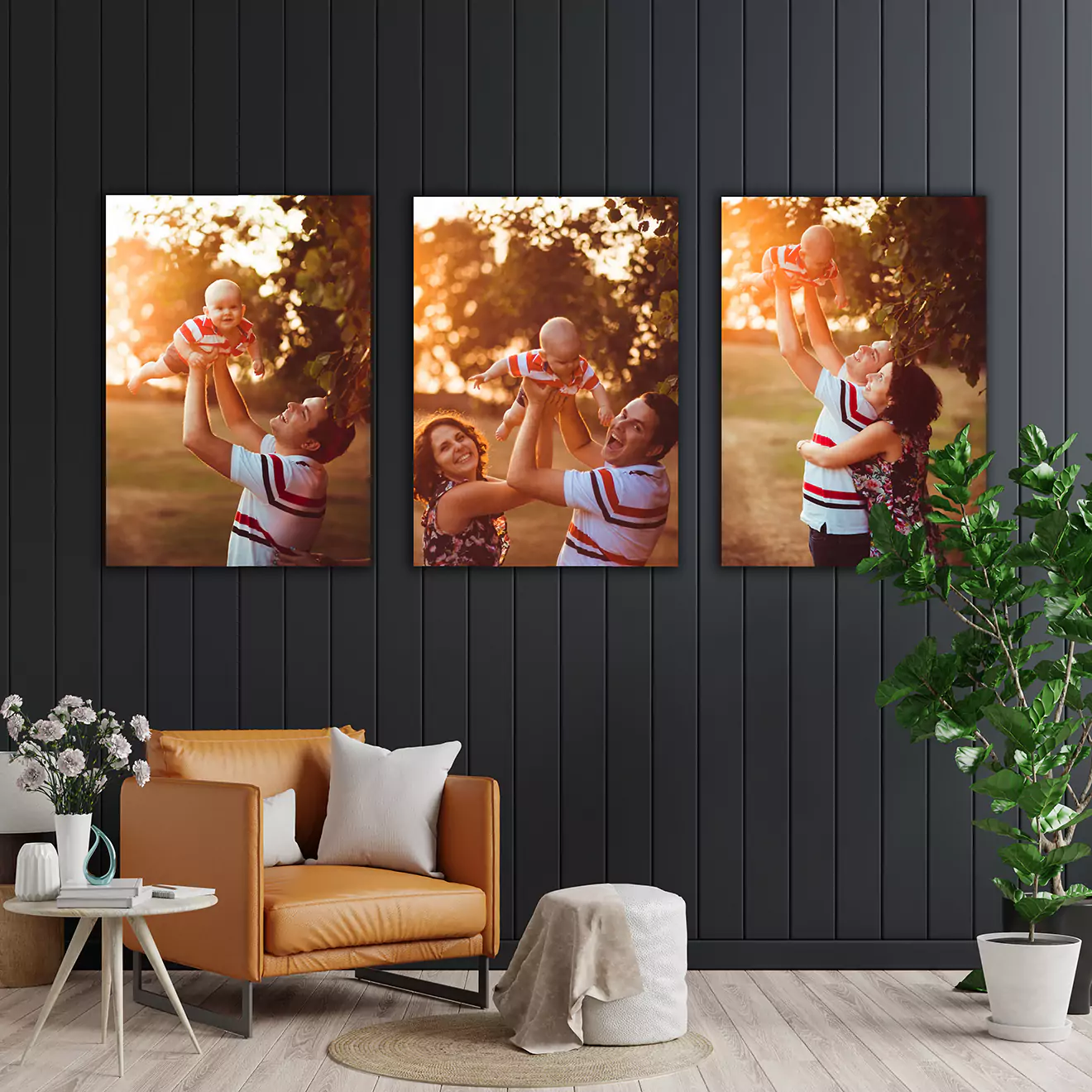 Alt tag: "Living room with modern decor featuring a set of three wall art pieces depicting a family enjoying outdoor moments with their baby. The room includes a tan leather chair, a small table, and green plants.