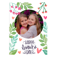 Floral-themed Mother's Day greeting card featuring a circular photo of two smiling children. The card is adorned with green leaves, pink and red flowers, and heart illustrations. The text "Happy Mother's Day" is written in a decorative font below the photo.