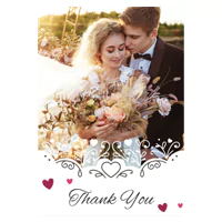 Elegant wedding-themed greeting card featuring a romantic photo of a bride and groom embracing, with the bride holding a bouquet of flowers. The card is adorned with decorative heart motifs and the words "Thank You" in stylish script at the bottom. Ideal for wedding thank-you notes and personalised gifts.