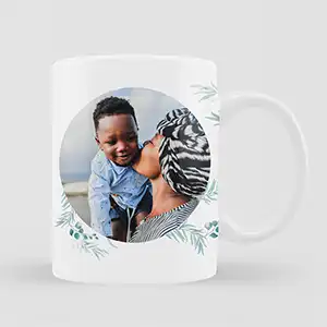 White ceramic mug featuring a personalised photo of a woman and child, surrounded by a delicate blue gum leaf design. Ideal for gifts for men, baby shower gift ideas, Christmas gifts, or personalised gifts in South Africa. Perfect for adding a personal touch to your morning coffee.