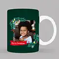 Personalised Christmas-themed mug featuring a festive wreath design. The mug has a dark green background with a photo space in the centre, surrounded by Christmas wreaths and a 'Merry Christmas' message. Ideal for Christmas gifts, gifts for her, or gifts for dad.