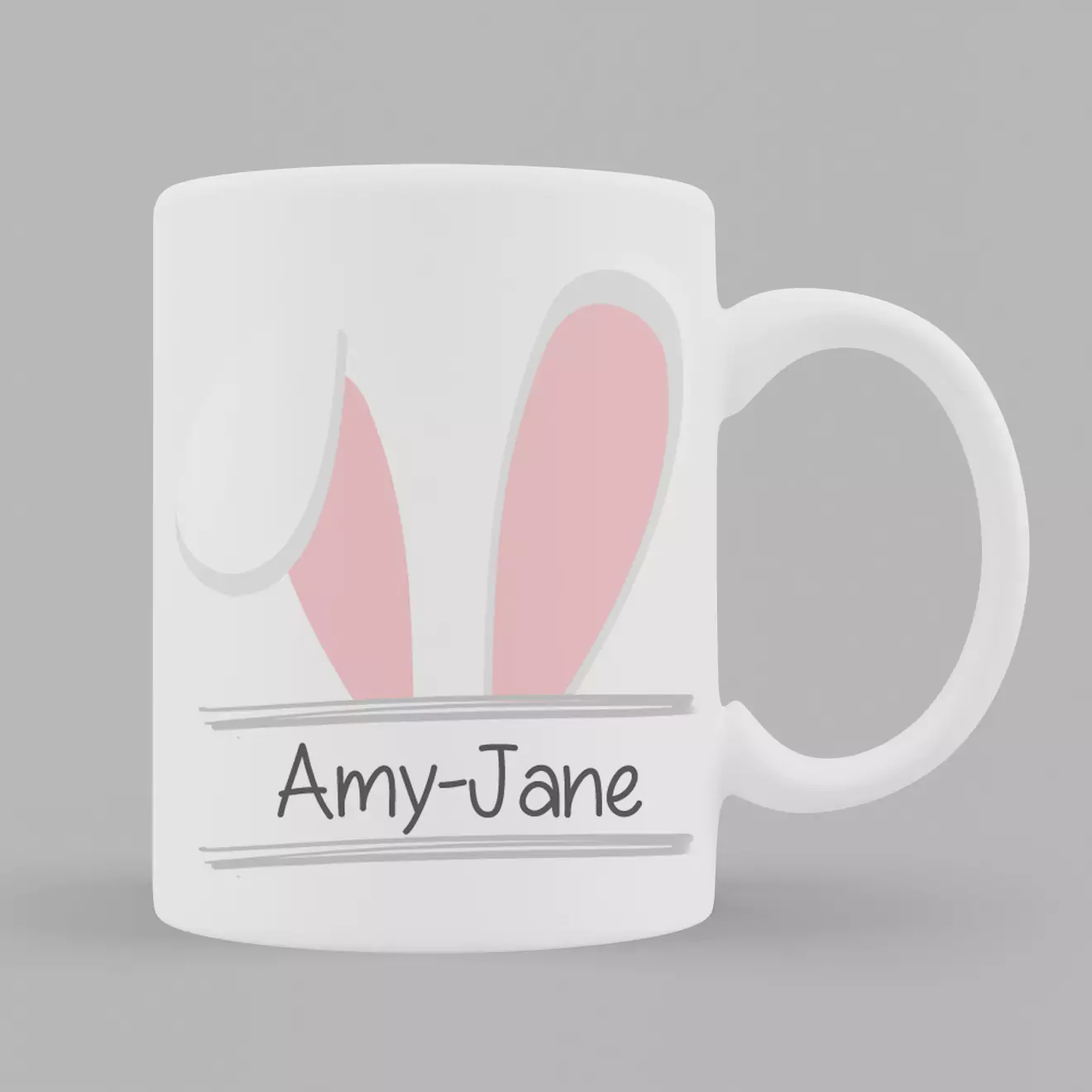 White ceramic Easter-themed mug featuring pink bunny ears and a personalised name "Amy-Jane" in playful font. Ideal as a personalised gift for Easter, suitable for both men and women. Perfect for enjoying hot beverages and adding a festive touch to your kitchenware.