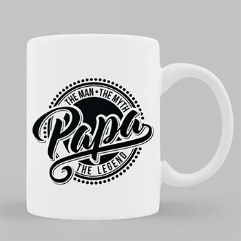 White ceramic mug with black text that reads "The Man, The Myth, Papa, The Legend" in a stylish font. The mug is filled with tea and placed on a desk with office supplies, including headphones and a plant. Ideal for gifts for dad, personalised gifts in South Africa, and Christmas gift ideas.