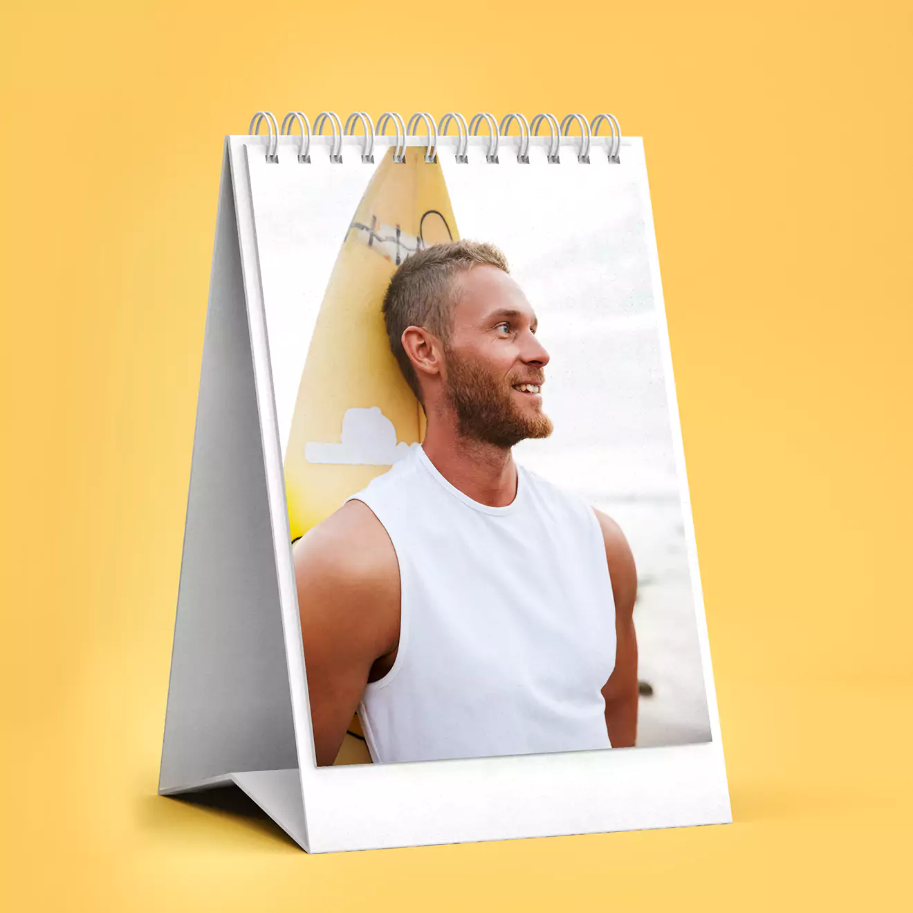 Personalised desk photo flipbook with a spiral binding, featuring a smiling man in a white sleeveless shirt on the cover. The calendar is set against a bright yellow background, making it a vibrant and cheerful addition to any workspace. Ideal for gifts for men, Christmas gift ideas, and personalised gifts in South Africa.