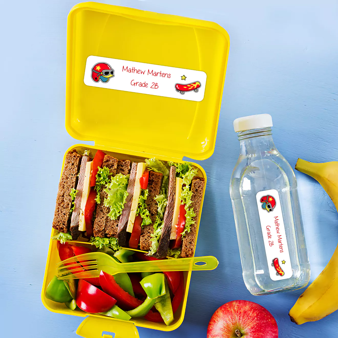 School lunch box and juice bottle adorned with personalised stickers, adding a unique and fun touch to school essentials.