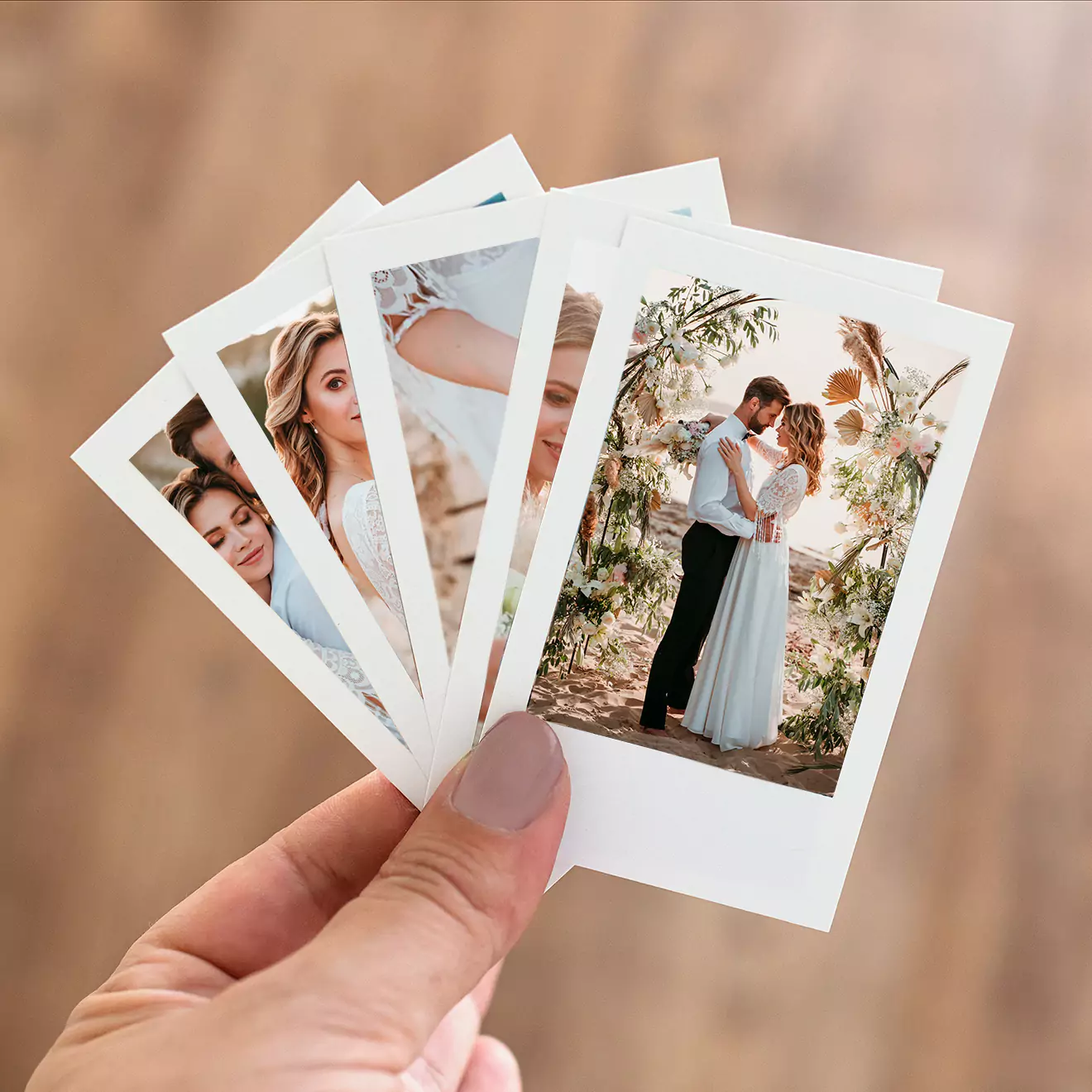 A hand holding a set of five printed polaroid-style photos featuring a couple in various romantic poses. The images are vibrant and clear, showcasing moments of affection and joy. These personalised photo prints make for thoughtful gifts, ideal for occasions like Valentine's Day, anniversaries, or as keepsakes.