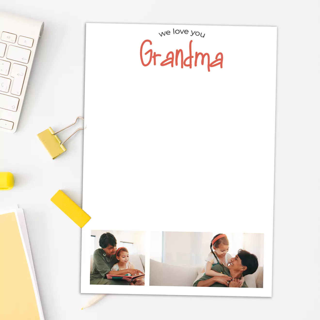 Personalised white notepad with "We love you Grandma" written in red at the top. The notepad features two small family photos at the bottom, depicting a child and an adult. Ideal for gifting to grandparents, especially for occasions like Christmas or birthdays.